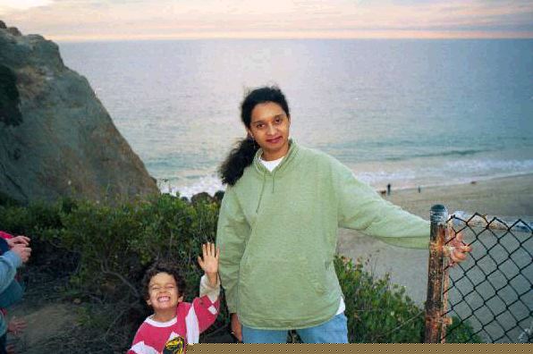 Monnica and Paul standing on a hill in front of the ocean