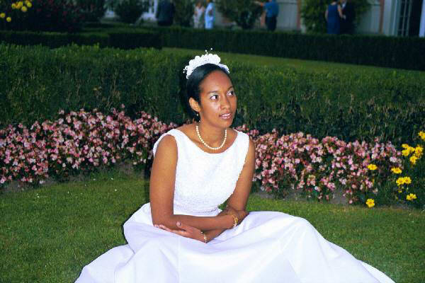 Sonya sits on the grass in her wedding dress
