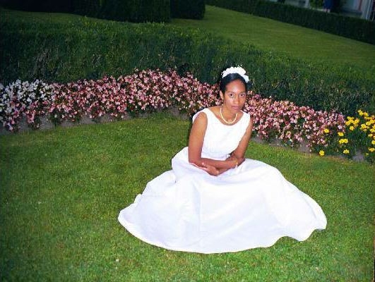 Sonya sits on the grass in her wedding dress